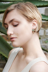 Model in green house wearing sustainable Ear-ringrings handmade in recycled sterling silver and gold